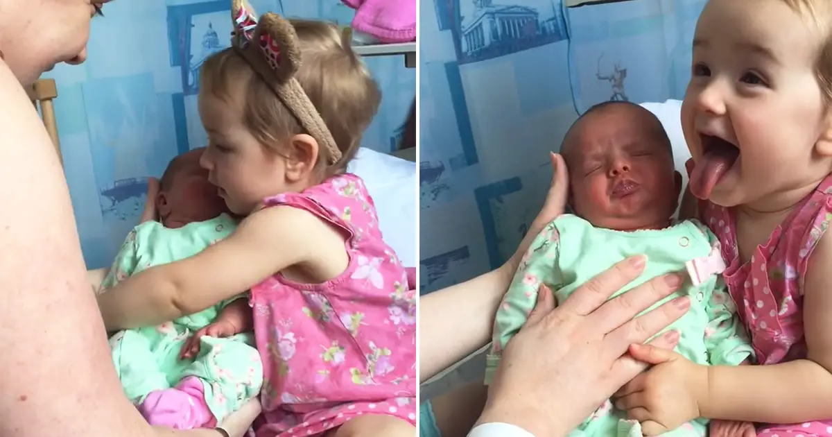toddler holds baby
