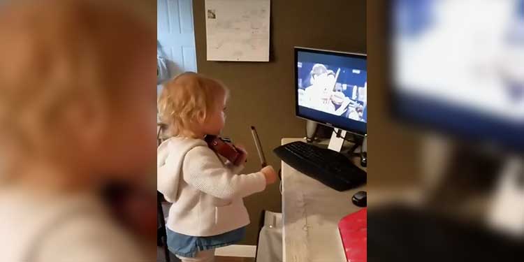 girl playing violin with tv